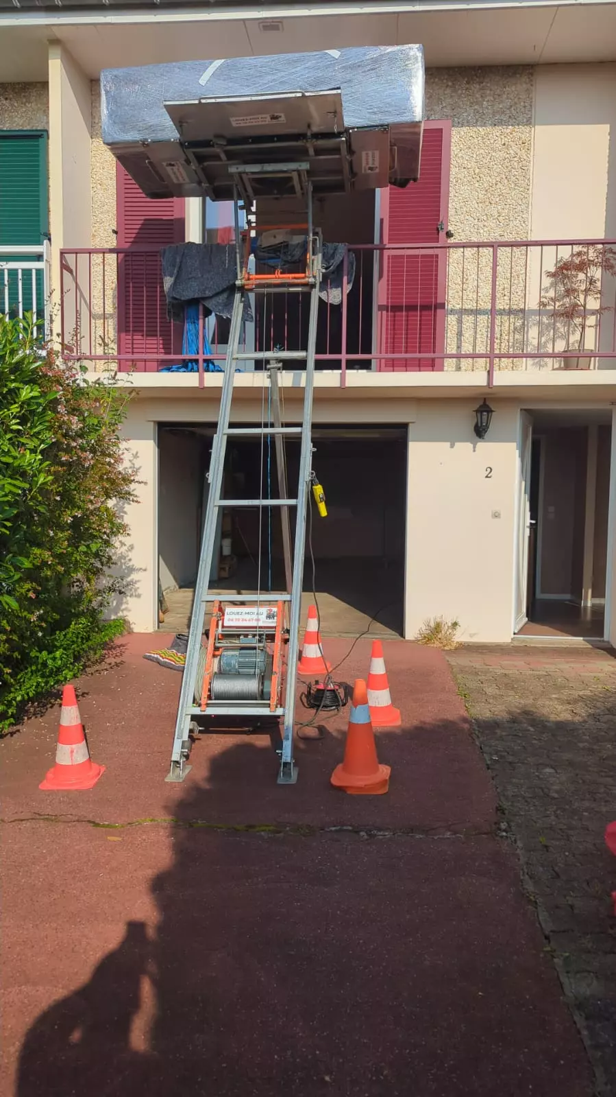 Un Monte meuble emboitable installé devant une maison par un déménageur