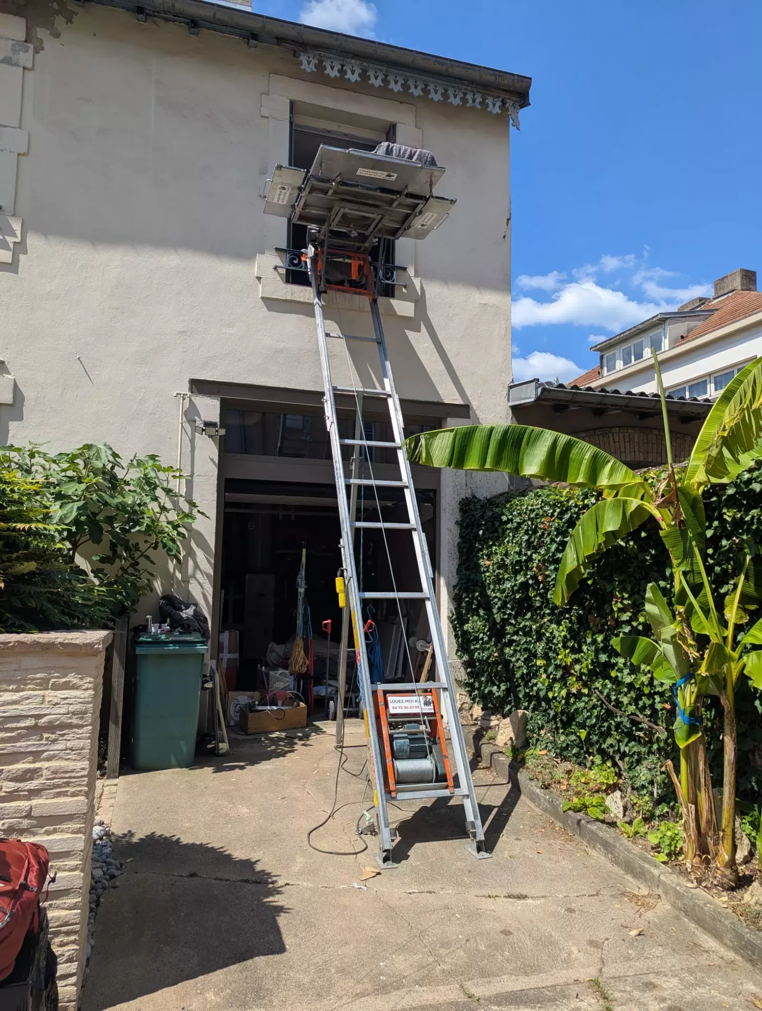 Un Monte meuble emboitable installé devant une maison par un déménageur
