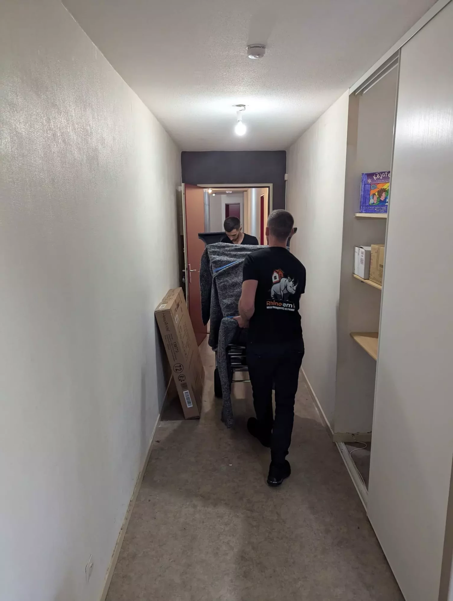 deux déménageurs portent un meuble